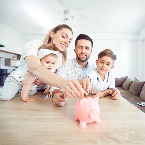 happy family putting change into a piggy bank