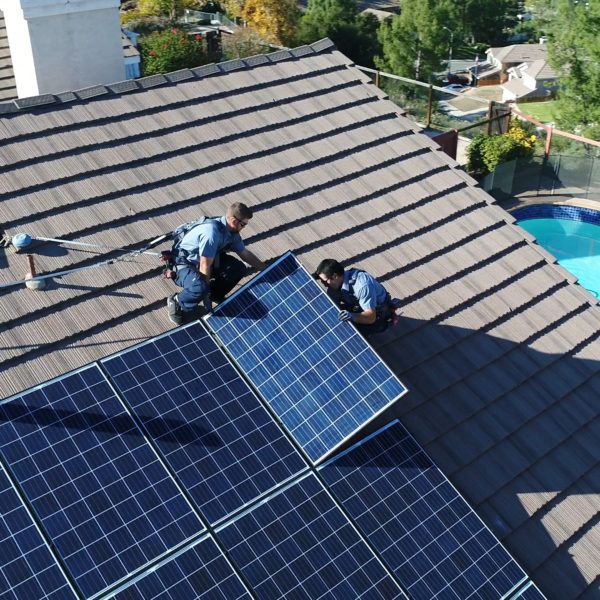 Two Mauzy technicians on the roof of a house installing a solar panel