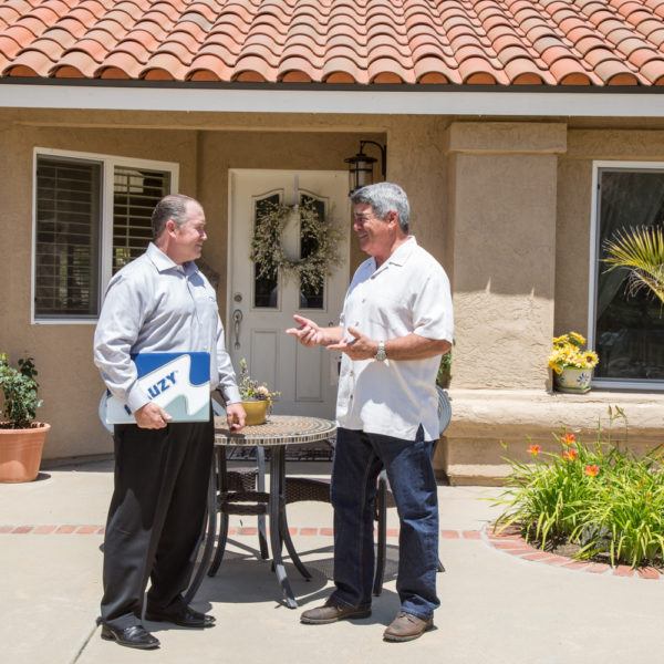 Mauzy comfort advisor and homeowner standing in front of the home talking