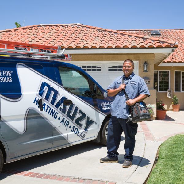 Mauzy technician posing next to van in front of customer's home for a heating repair