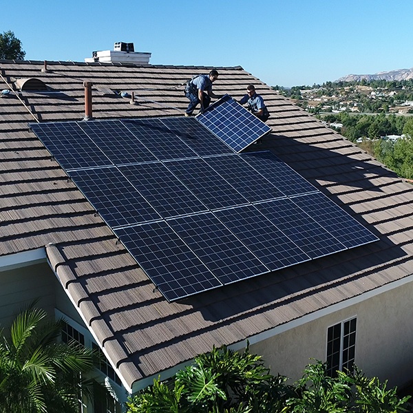 Two Mauzy technicians repairing solar panels on a roof